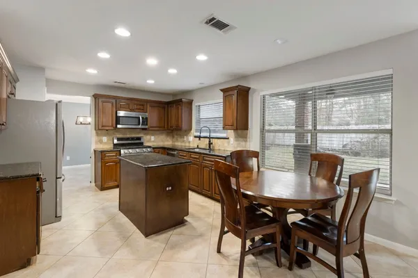 a kitchen with a table chairs refrigerator and cabinets