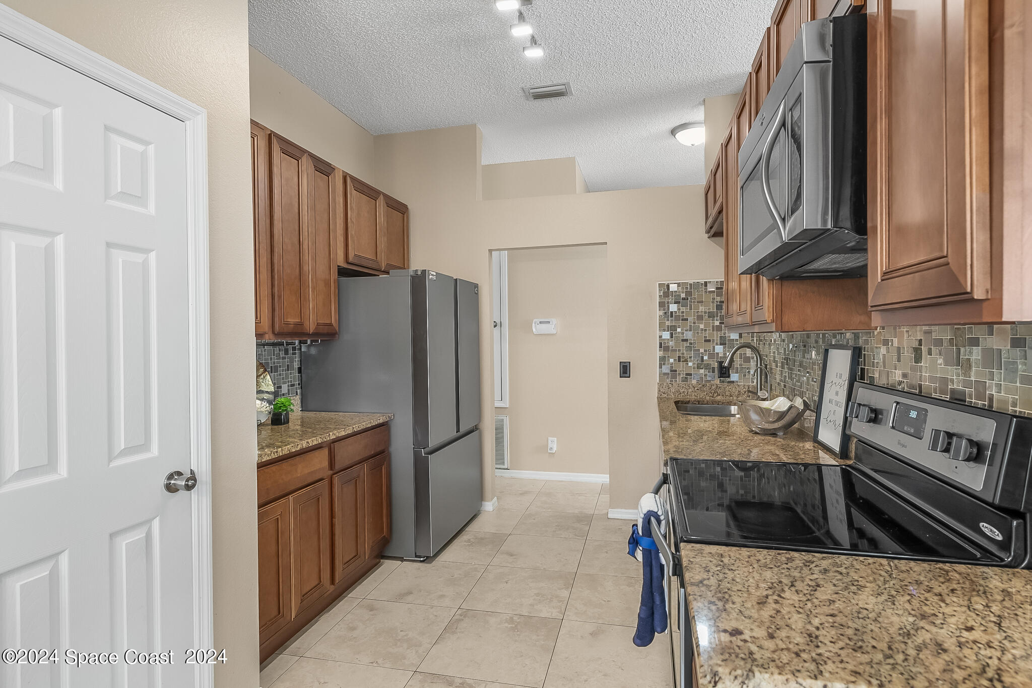 4631 Decatur Circle Melbourne, FL 32934 - Photo 17 of 35 a kitchen with stainless steel appliances granite countertop a refrigerator and a sink
