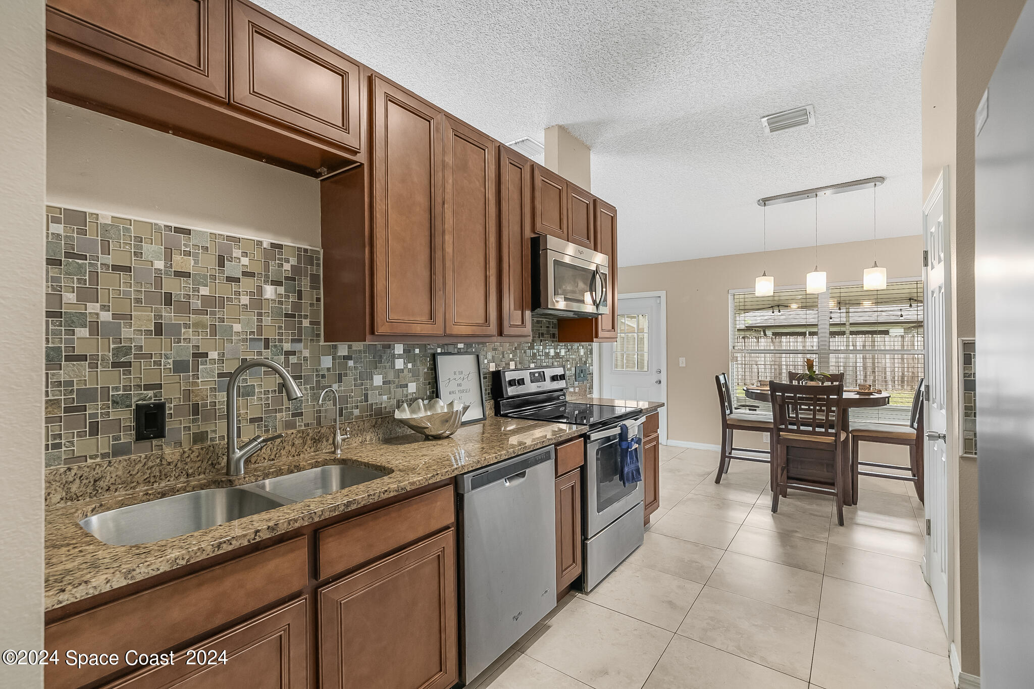 4631 Decatur Circle Melbourne, FL 32934 - Photo 18 of 35 a kitchen with stainless steel appliances granite countertop a sink stove and cabinets