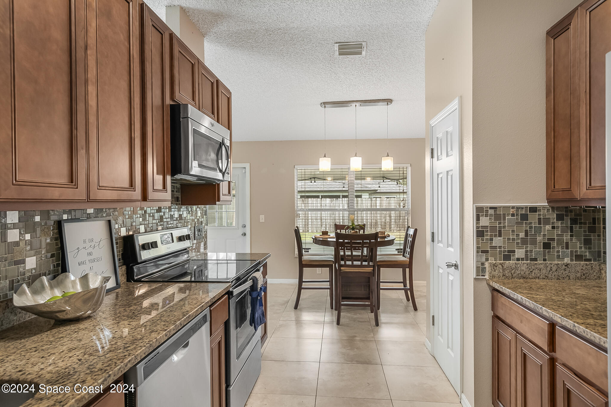 4631 Decatur Circle Melbourne, FL 32934 - Photo 19 of 35 a kitchen with stainless steel appliances granite countertop a stove top oven a sink a counter space and cabinets