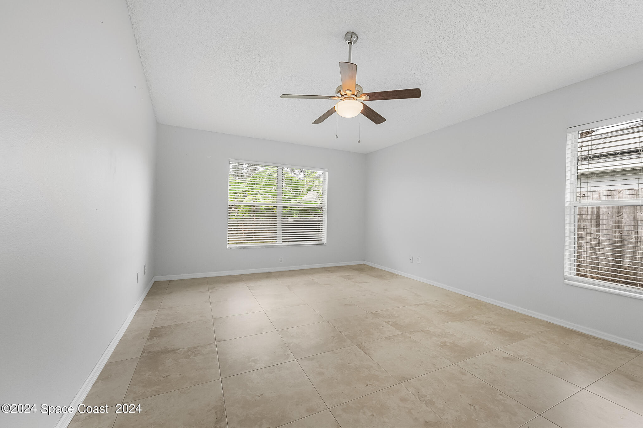 4631 Decatur Circle Melbourne, FL 32934 - Photo 21 of 35 an empty room with windows and fan