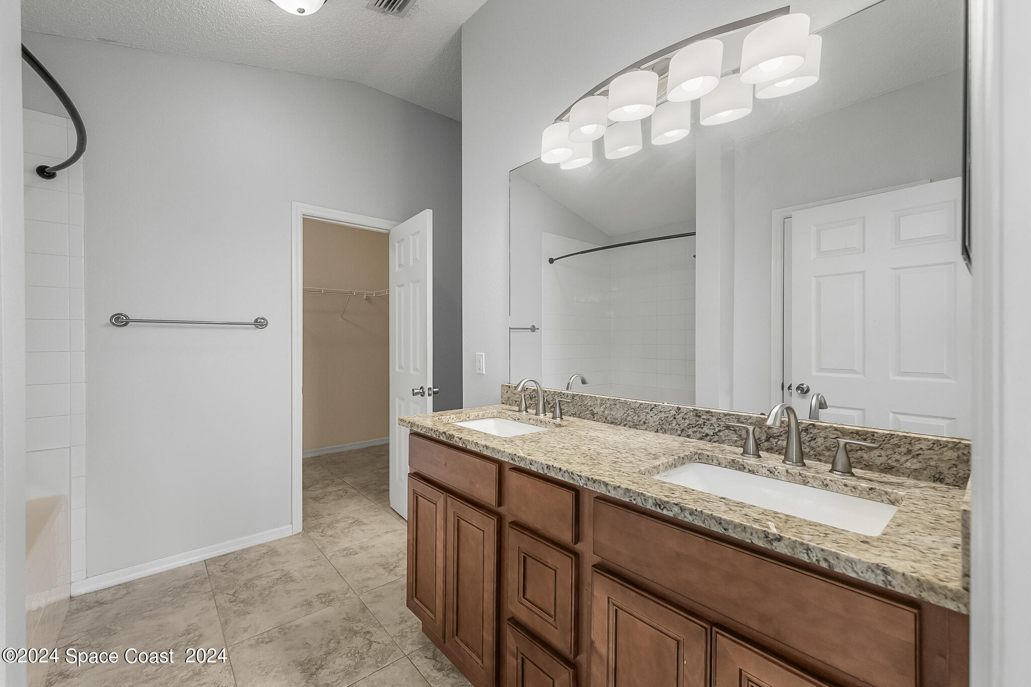 4631 Decatur Circle Melbourne, FL 32934 - Photo 23 of 35 a bathroom with a granite countertop sink and a mirror
