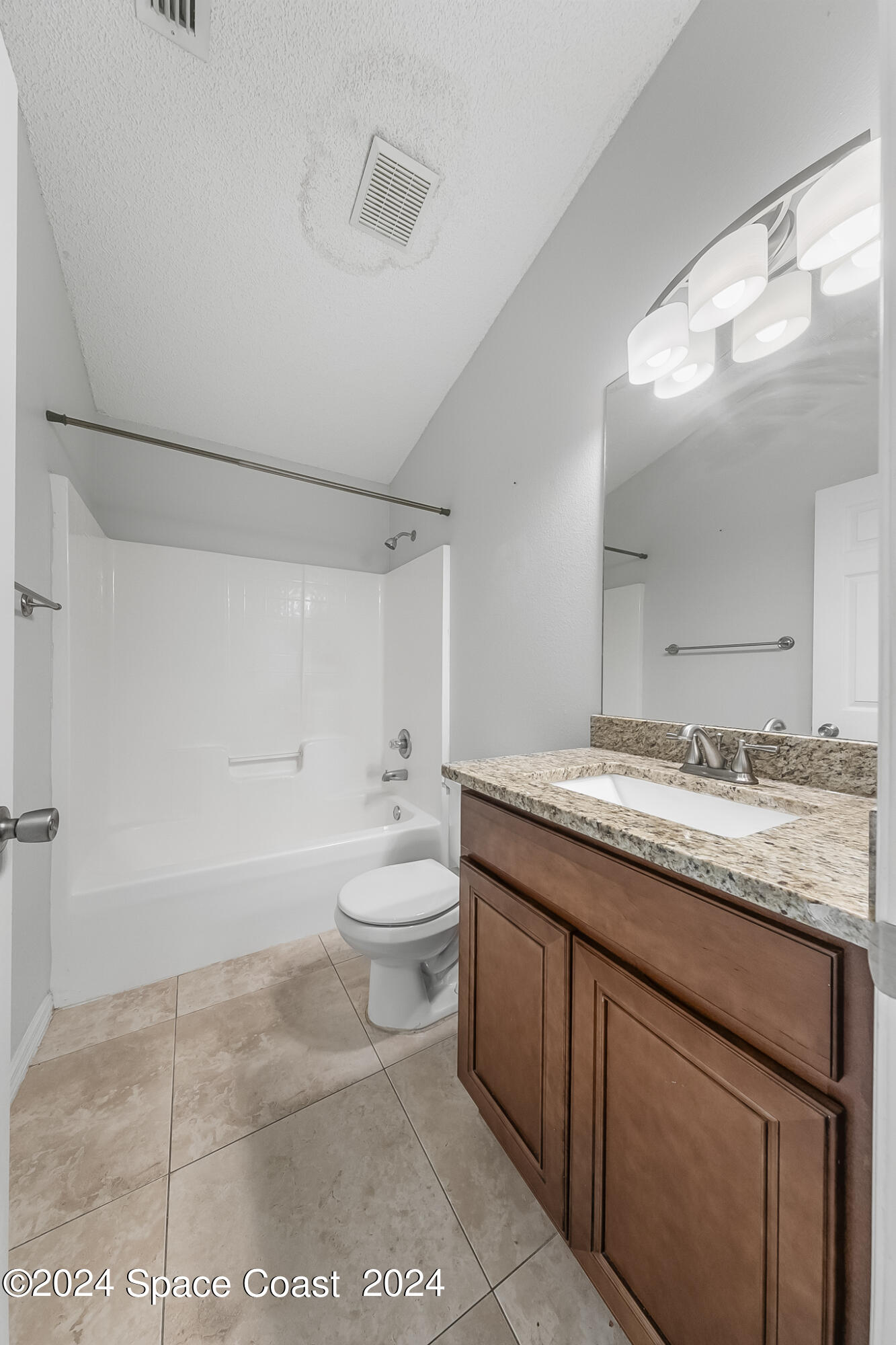 4631 Decatur Circle Melbourne, FL 32934 - Photo 27 of 35 a bathroom with a granite countertop sink a toilet and a mirror