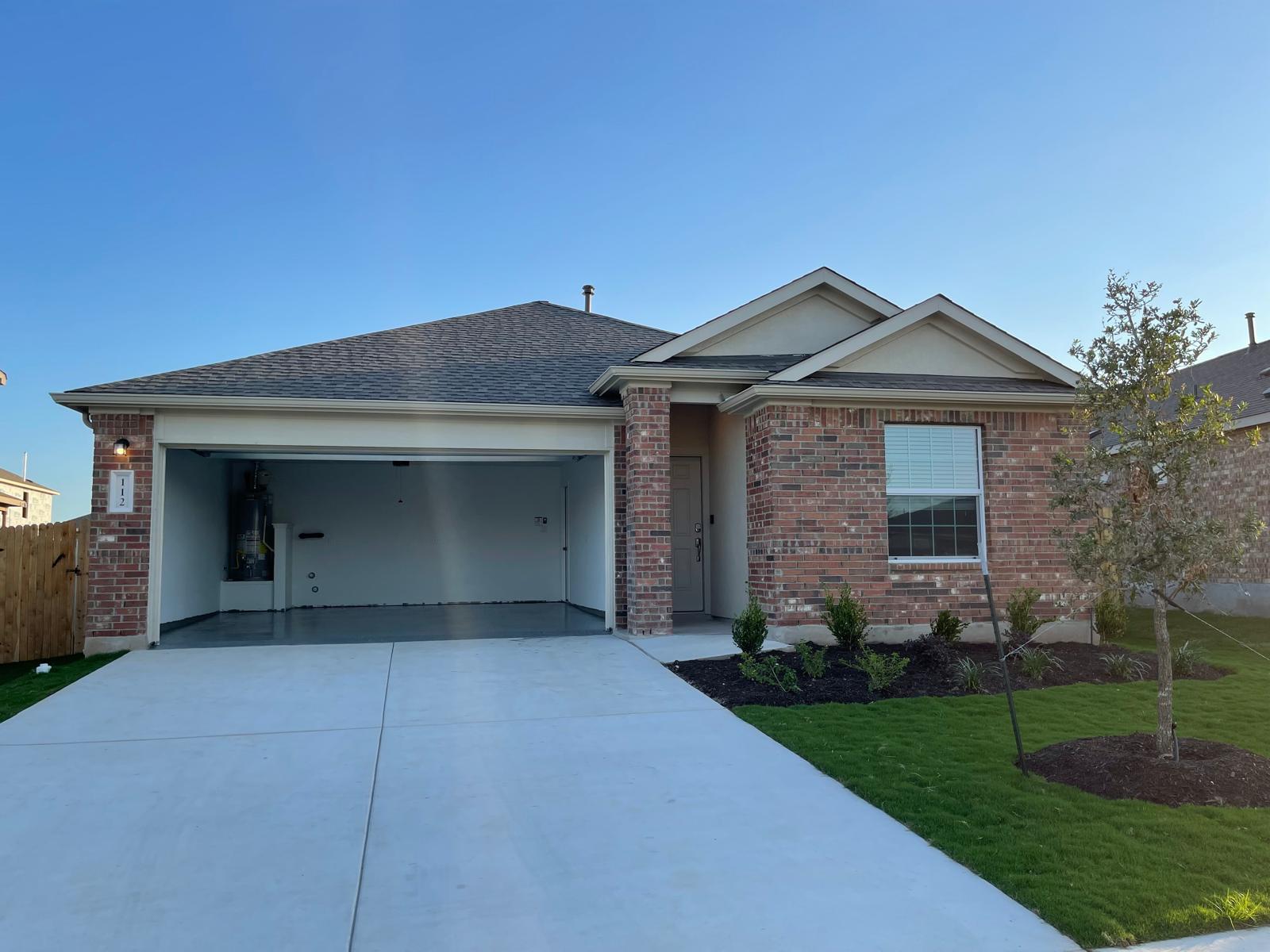 112 Concho Brook Bend Georgetown, TX 78626 - Photo 1 of 20 a front view of a house with a garden and yard