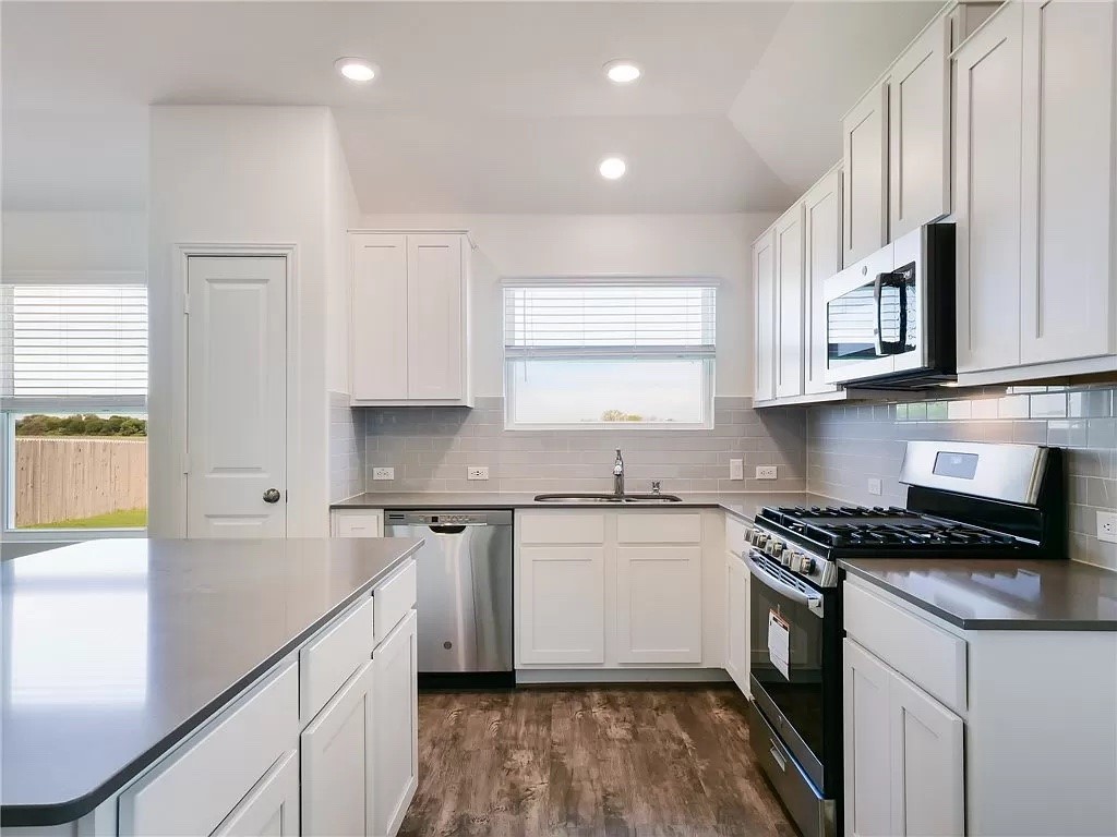 112 Concho Brook Bend Georgetown, TX 78626 - Photo 2 of 20 a kitchen with stainless steel appliances granite countertop a stove a sink and a microwave