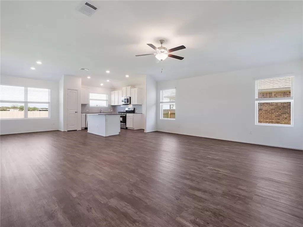 112 Concho Brook Bend Georgetown, TX 78626 - Photo 4 of 20 a view of an empty room with a window and wooden floor