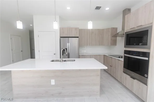 a kitchen with kitchen island a sink stainless steel appliances and cabinets
