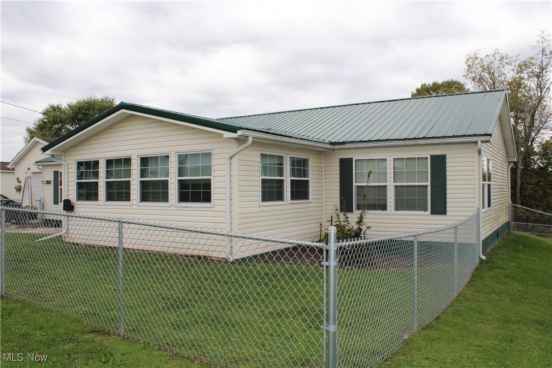 56 3rd Street Rayland, OH 43943 - Photo 6 of 46 View of home's exterior with a fenced backyard and a metal roof