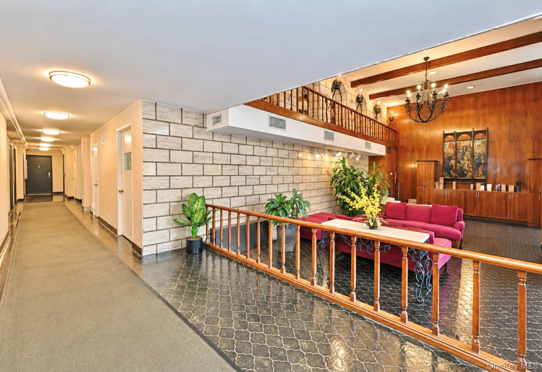 102-30 66th Road, Unit 17E Queens, NY 11375 - Photo 16 of 21 Two-story entry foyer featuring wood-finish paneling, a chandelier, and exposed ceiling beams