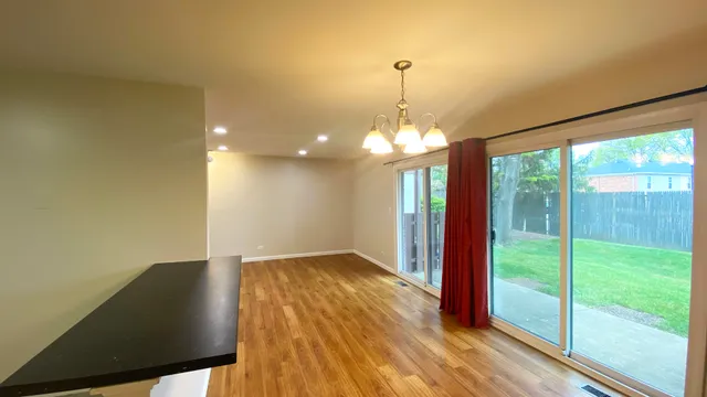 a view of a livingroom with wooden floor and a large window