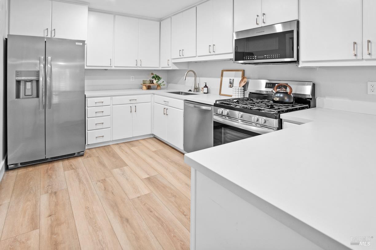 16 Drakes View Circle Greenbrae, CA 94904 - Photo 14 of 45 a kitchen with stainless steel appliances a sink dishwasher a refrigerator a microwave oven and cabinets with wooden floor