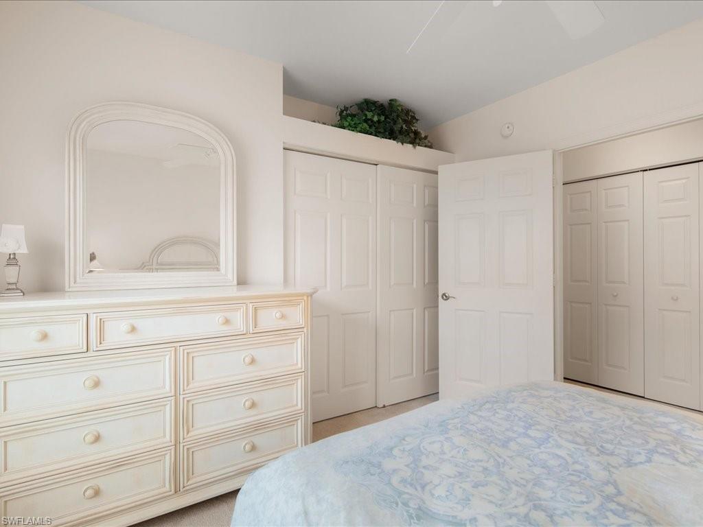 10910 Oak Island Road, Unit 103 Estero, FL 34135 - Photo 14 of 24 a bedroom with a bed and a mirror on the dresser