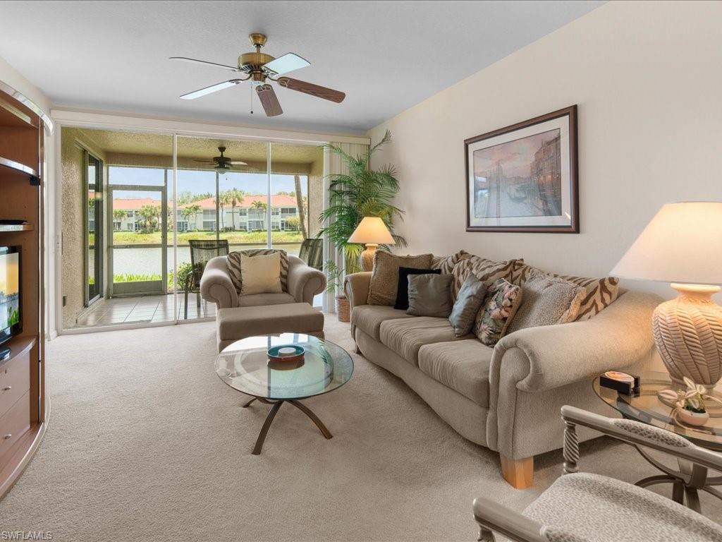 10910 Oak Island Road, Unit 103 Estero, FL 34135 - Photo 3 of 24 a living room with furniture a chandelier and a large window