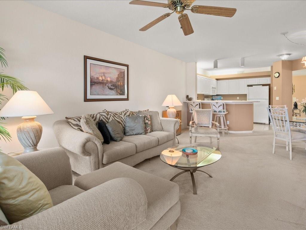 10910 Oak Island Road, Unit 103 Estero, FL 34135 - Photo 4 of 24 a living room with furniture a rug and a view of kitchen