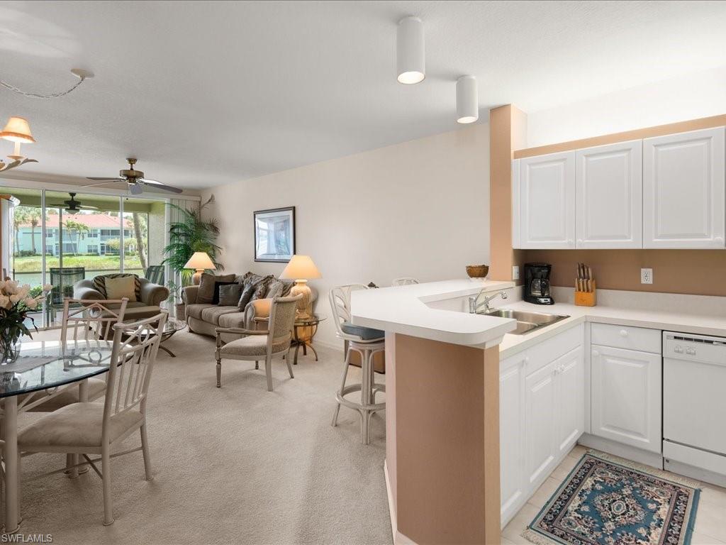 10910 Oak Island Road, Unit 103 Estero, FL 34135 - Photo 5 of 24 a living room with stainless steel appliances kitchen island granite countertop a sink and white cabinets