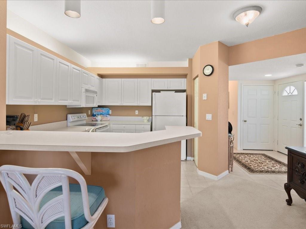 10910 Oak Island Road, Unit 103 Estero, FL 34135 - Photo 6 of 24 a kitchen with stainless steel appliances a sink and a refrigerator