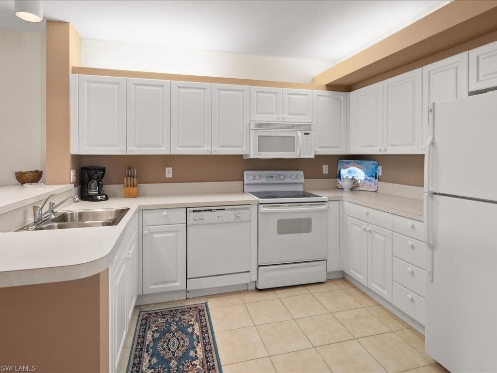 10910 Oak Island Road, Unit 103 Estero, FL 34135 - Photo 7 of 24 a kitchen with a sink stove and cabinets