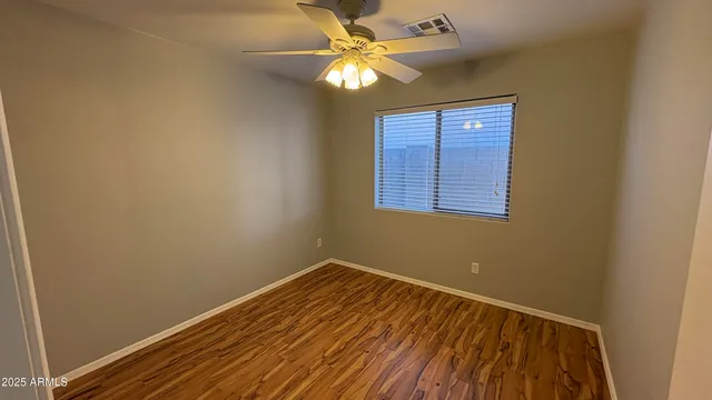 an empty room with a window and a fan