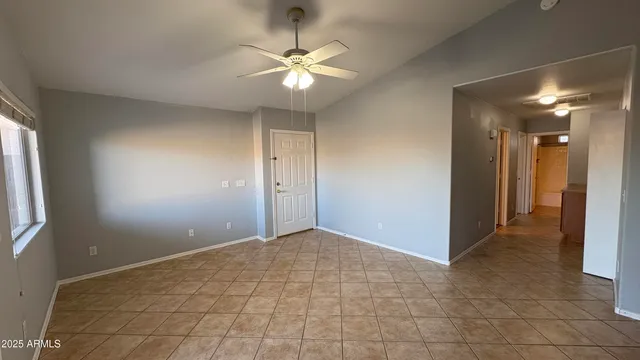 a view of an empty room with a chandelier fan