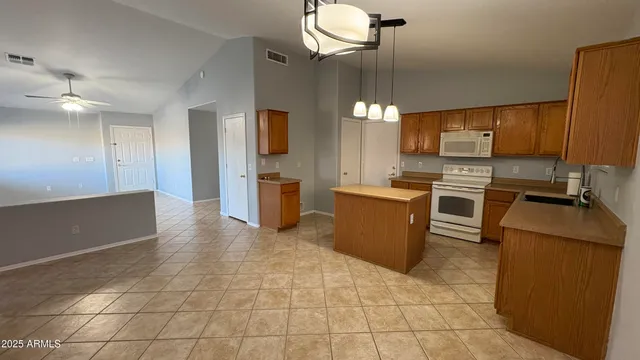 a kitchen with stainless steel appliances a stove a refrigerator a sink a oven with a dining table and chairs