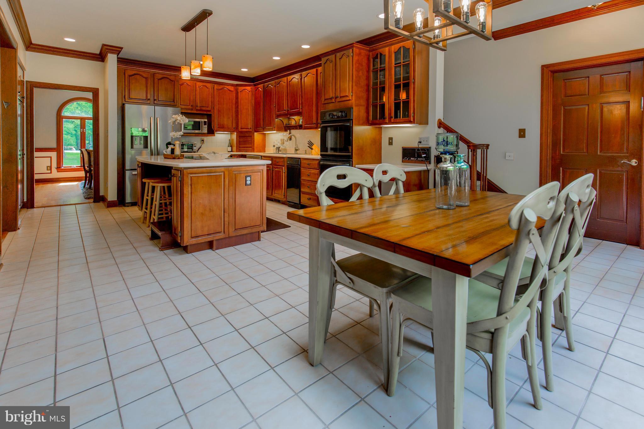 610 Bryants Nursery Road Silver Spring, MD 20905 - Photo 11 of 30 a dining hall with stainless steel appliances granite countertop a stove a sink a refrigerator dining table and chairs