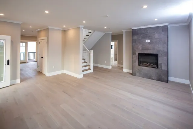 a view of empty room with wooden floor and fireplace