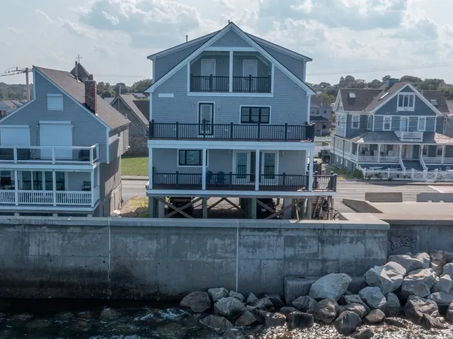 a view of a house with wooden deck and furniture