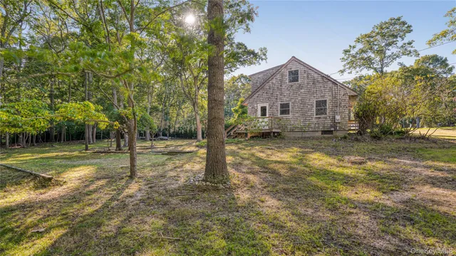 a view of a house with backyard and trees