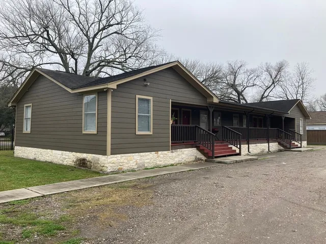 a view of a house with a yard and large tree