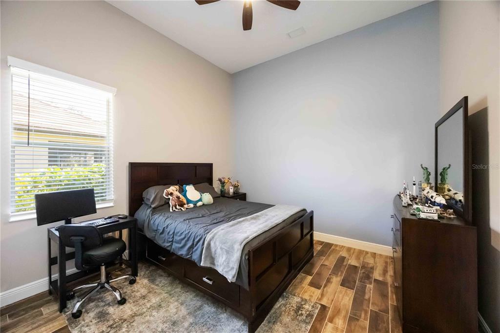 14806 Bowfin Terrace Lakewood Ranch, FL 34202 - Photo 41 of 95 a bedroom with a bed table chair and a window