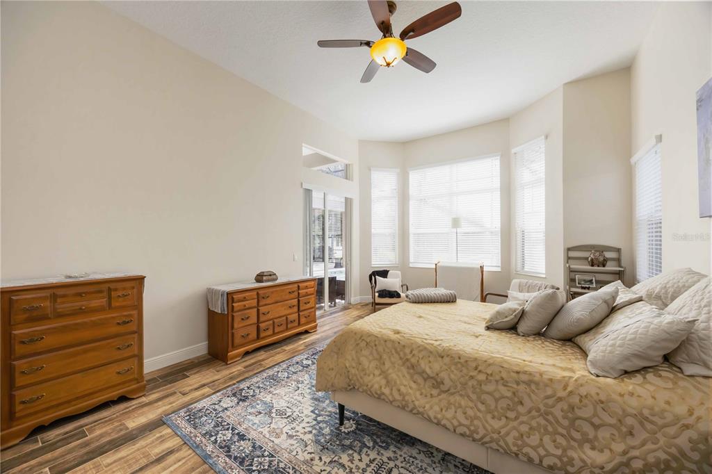 14806 Bowfin Terrace Lakewood Ranch, FL 34202 - Photo 50 of 95 a spacious bedroom with a bed a dresser and with couch