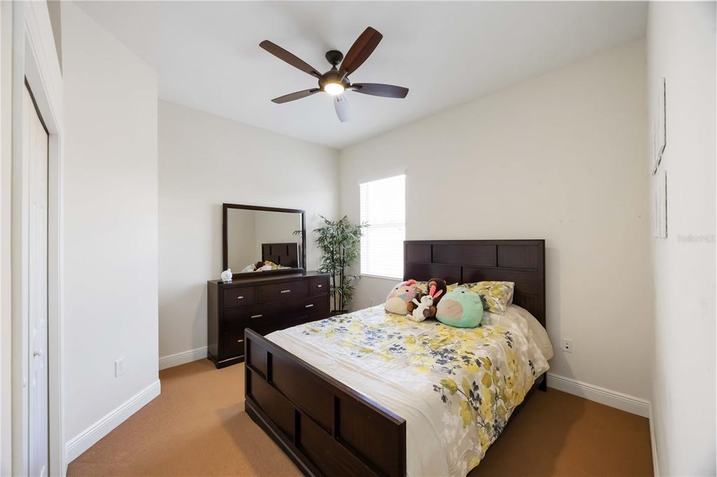 14806 Bowfin Terrace Lakewood Ranch, FL 34202 - Photo 61 of 95 a bedroom with a bed and a tv on the dresser