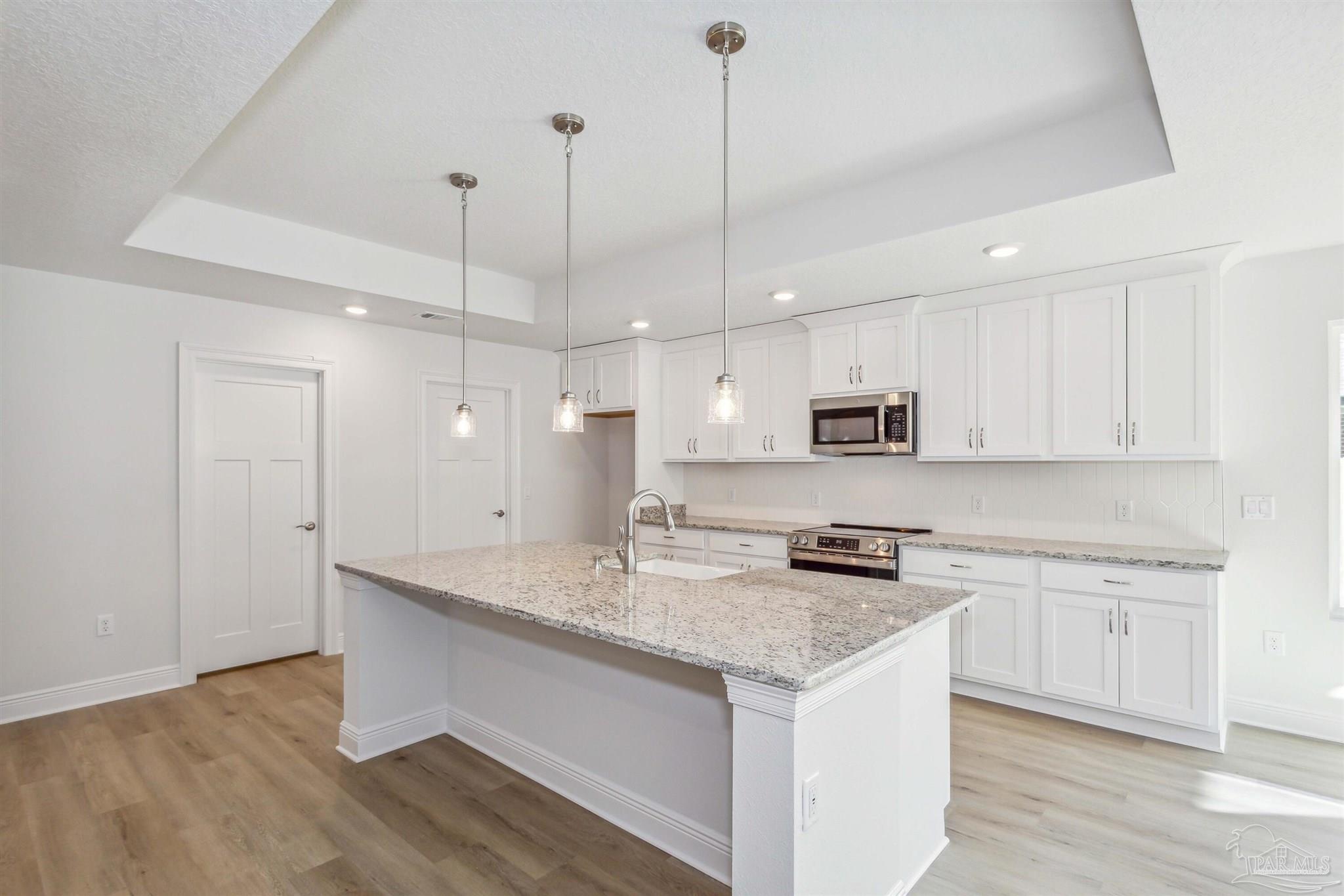 4655 Carl Booker Road Milton, FL 32583 - Photo 2 of 4 a kitchen with kitchen island granite countertop a sink a counter space appliances and cabinets