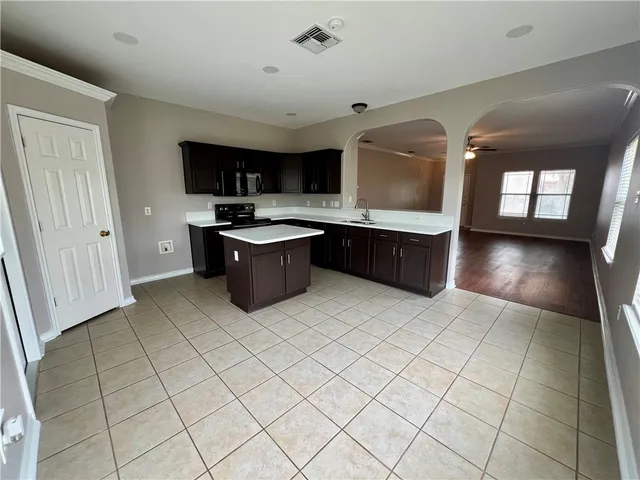 a kitchen with a sink a stove top oven and cabinetry