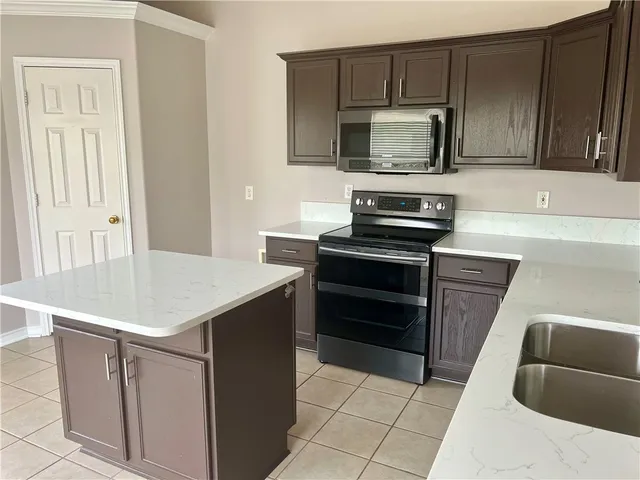 a kitchen with stainless steel appliances a sink stove and refrigerator