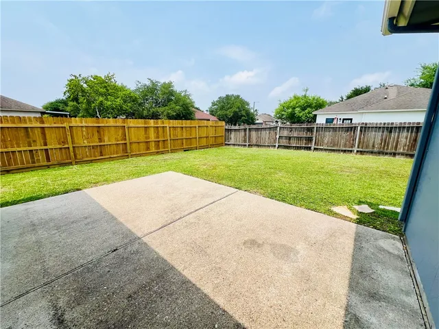 a view of a backyard with a small cabin and wooden fence