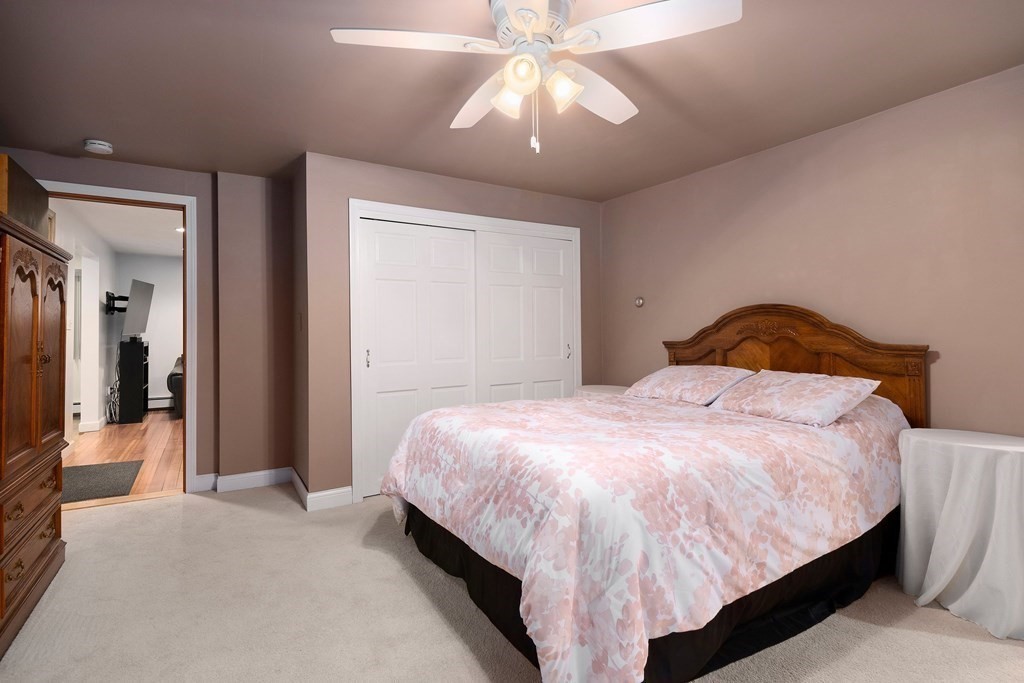 102 Orange Street Reading, MA 01867 - Photo 11 of 23 a bedroom with a bed and a chandelier