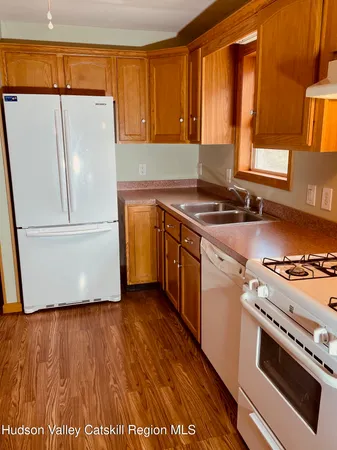 a kitchen with granite countertop wooden floors and white stainless steel appliances