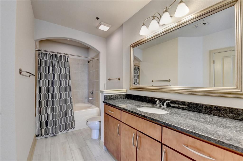 3445 Stratford Road Northeast, Unit 2106 Atlanta, GA 30326 - Photo 16 of 44 a bathroom with a granite countertop sink a toilet a mirror and shower