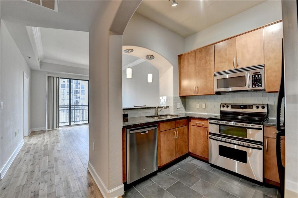 3445 Stratford Road Northeast, Unit 2106 Atlanta, GA 30326 - Photo 5 of 44 a kitchen with stainless steel appliances granite countertop a stove top oven and sink