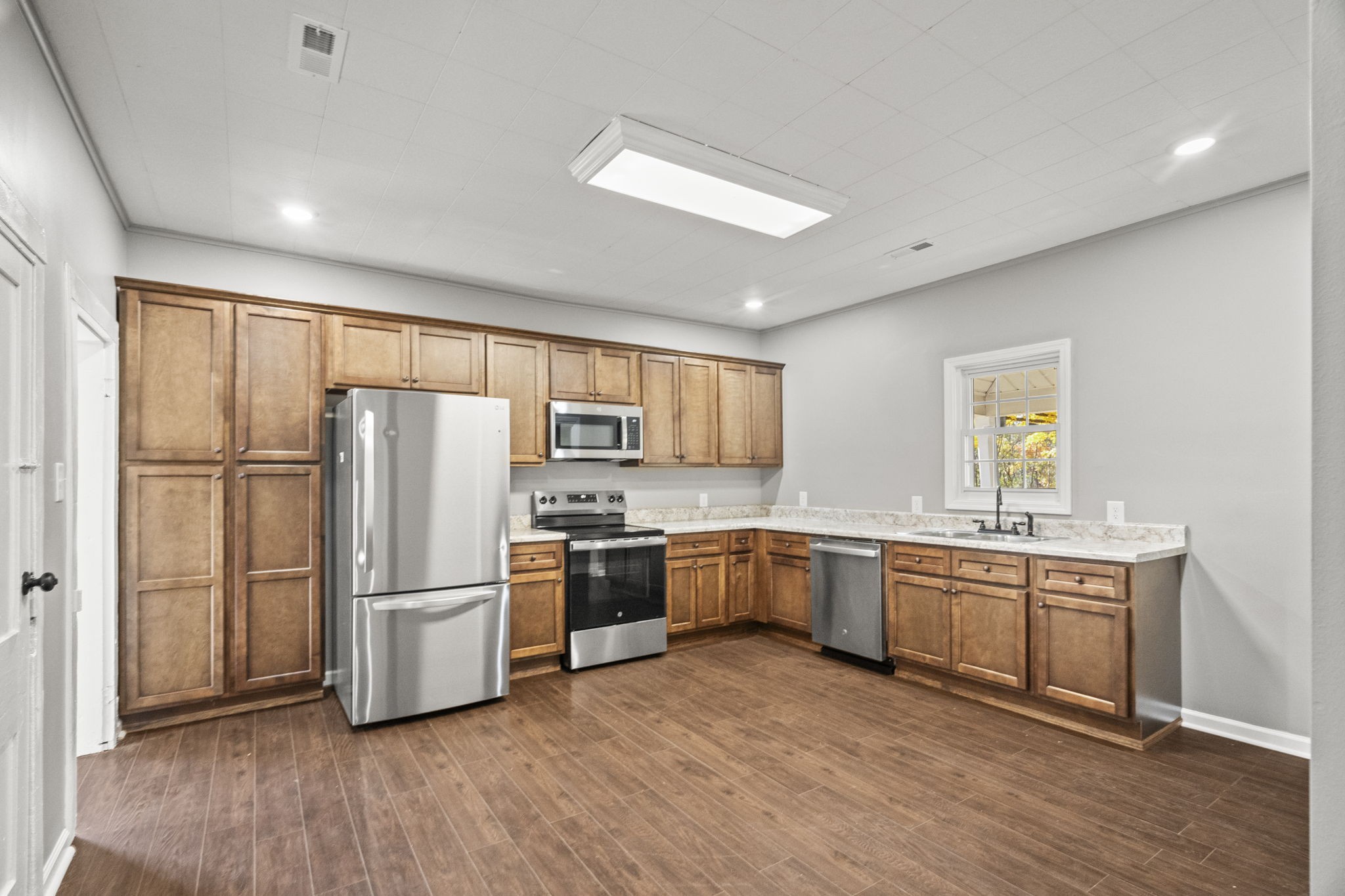 6081 Lakeview Road Springfield, TN 37172 - Photo 2 of 41 a kitchen with stainless steel appliances granite countertop a refrigerator a stove top oven a sink and dishwasher with wooden floor