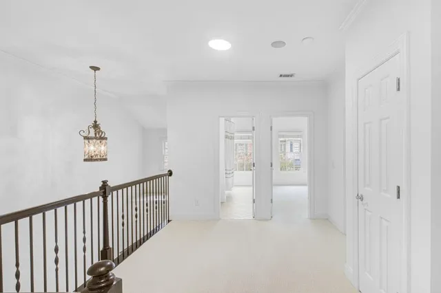 a view of a hallway with chandelier and entryway