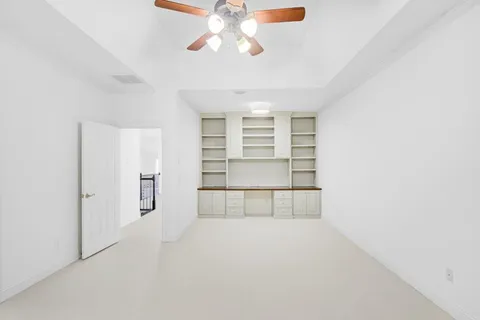 an empty room with windows and cabinet