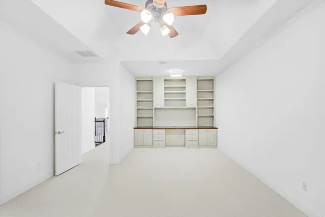 an empty room with windows and cabinet