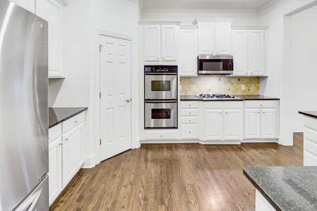 a kitchen with stainless steel appliances granite countertop a refrigerator and a stove top oven