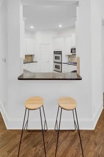 a view of a room with chairs and wooden floor