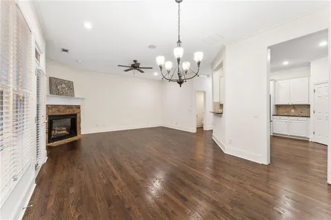 a view of a room with wooden floor and a kitchen