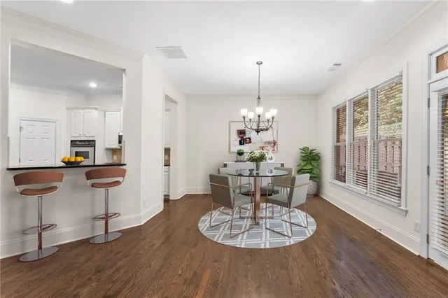 a view of a dining room with furniture a chandelier and wooden floor