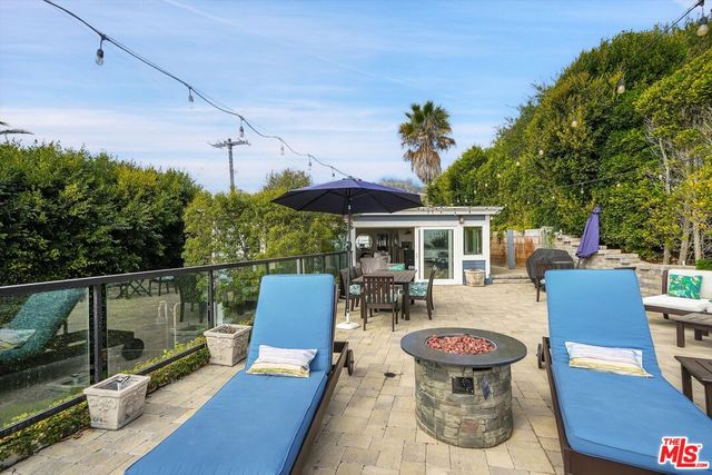 a view of a patio with a dining table and chairs with a fire pit