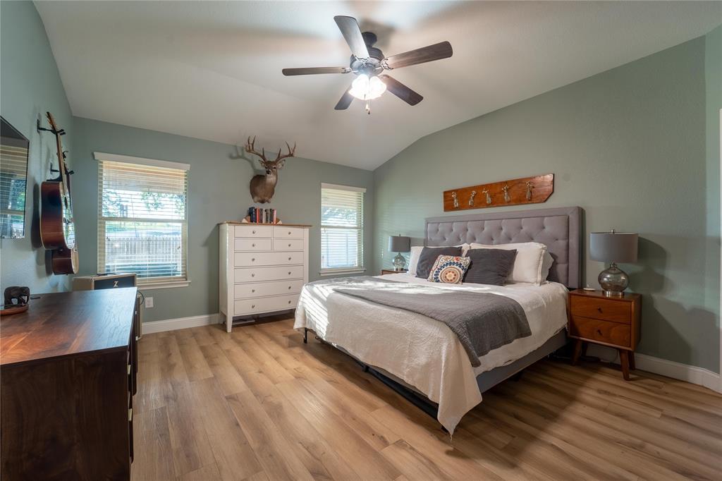 5521 Wisdom Court Waco, TX 76708 - Photo 18 of 28 Vaulted ceiling with a ceiling fan, light wood-finish flooring, two windows with blinds, and light-colored walls